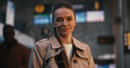 Obraz premium Stylish and Professional Young Woman Stands Confidently in Airport Departure Hall. Positive Emotions of Travel, Holiday Anticipation, and Carefree Lifestyle of Modern Independent Woman. Portrait.