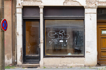 Retail vacancy with damaged plaster facade and signs of urban decay. Symbolic image for vacancy and structural change. © EKH-Pictures