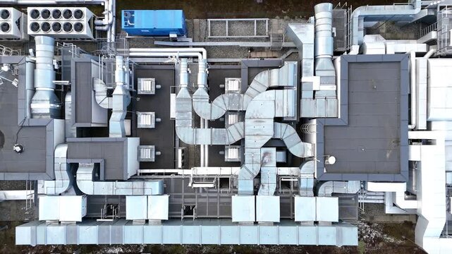 Aerial view of industrial rooftop showcasing extensive HVAC system with interconnected ducts, vents, and units demonstrating complex engineering and design in a modern facility layout