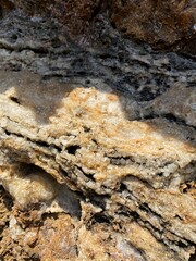 Obraz premium The texture of the stone is a close-up under the sunlight. Rocks with minerals on the shores of the Mediterranean Sea in Camyuva, near Kemer, Turkey. Layered structure.