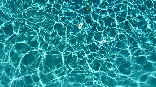 Blue water in the swimming pool with light reflections. 