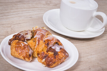 Croissants from polish city Poznan baked according to traditional recipe with poppy seed filing and cup of coffee