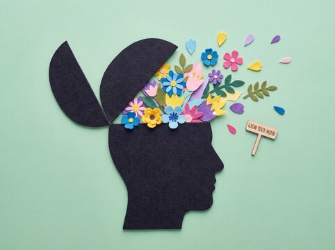 Human head silhouette with open mind and colorful flowers inside on pastel green background, flat lay concept for mental health or brain activity idea.	