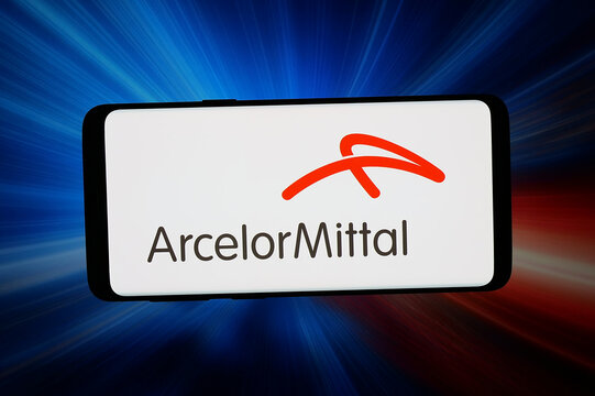 Stuttgart, Germany - 03-19-2026: In this photo illustration, the logo of steel company ArcelorMittal S.A. is displayed on a smartphone in front of abstract background on computer screen.