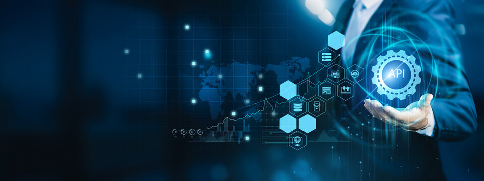 Technology professional holding laptop integrating platforms. API enables seamless communication between applications, improving connectivity, data exchange, and system scalability.