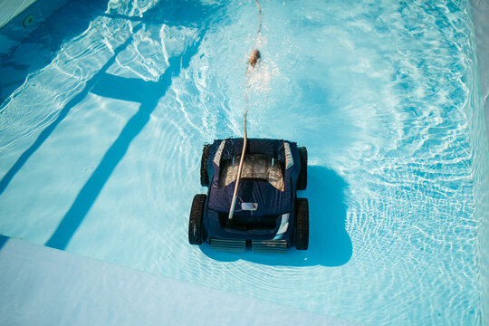 Robotic pool cleaner working underwater to keep swimming pool clean.