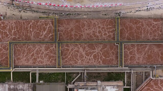 Aerial view of the water treatment plant with its brown water tanks divided by yellow lines creating a grid-like pattern, Avezzano, Abruzzo, Italy.