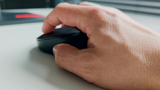 Hand of working person holding computer mouse on desk, office workspace detail with modern technology and everyday productivity concept. Work concept. 4K video footage