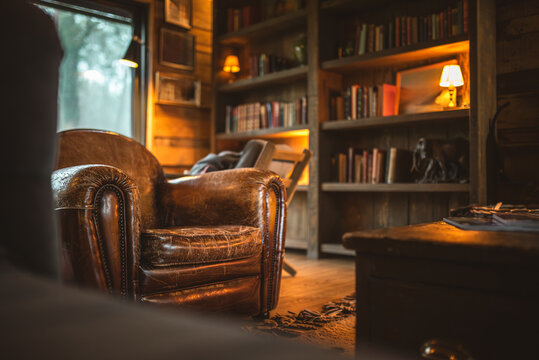 Cozy leather armchair in a rustic library with warm ambient lighting