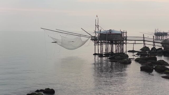 Aerial view of Trabucco stands tall on the coast, its intricate net casting shadows on the serene sea, San Vito Chietino, Abruzzo, Italy.