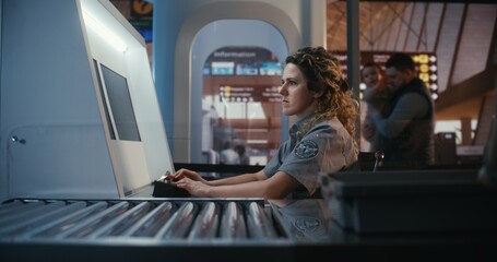 Focused Female Security Officer in Professional Uniform Operates Control Panel and Monitors X Ray Baggage Scanners at Busy Airport Terminal. Concept of Safety, Border Control, and Vigilance.