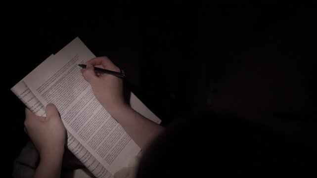 Man Reading and Making Notes at Night