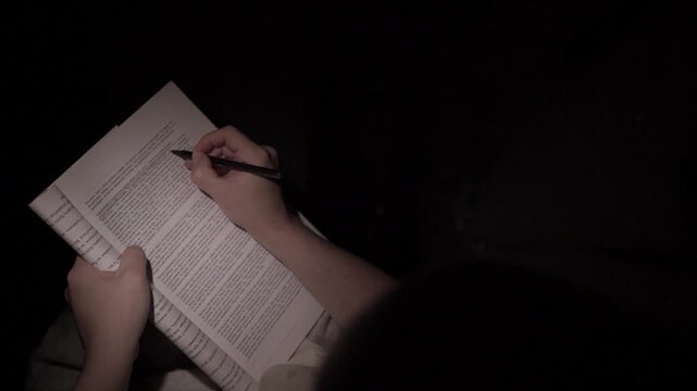 Man Reading and Making Notes at Night