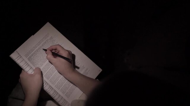 Man Reading and Making Notes at Night