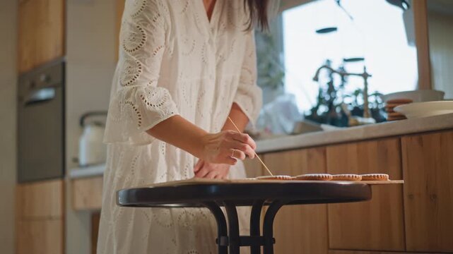 Woman preparing pumpkin pie on table, gentle sunlight in rustic kitchen as female baker presses crust into pan, precise hands shaping dough, spices and bowls on wooden counter, warm autumnal