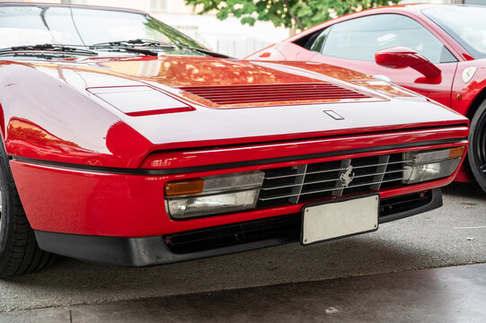 Mondov&igrave; (cuneo), italy, july 21, 2024. Ferrari rally. Front view of a red ferrari 328 gts parked with a modern ferrari in the background, representing italian automotive history