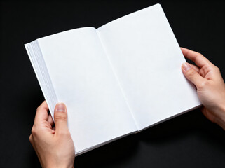 Obraz premium Hands holding open blank white book pages against a dark background