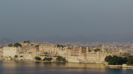 Fototapeta premium Drone View of City Palace Udaipur on Lake Pichola India Aerial Perspective of Royal Heritage Architecture with Scenic Rajasthan Cityscape