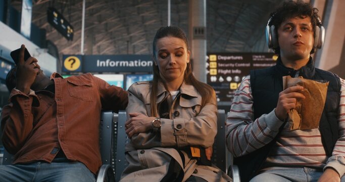 Highly Sensitive Passenger Sits Amidst Chaos of Terminal, Showing Signs Sensory Processing Struggle. Woman Remains Still and Focused, Regulating Emotions Against Loud Environment. Sensory Sensitivity.