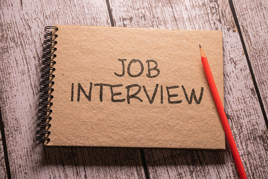 Job Interview Tips text written on chalkboard with alarm clock on wooden background.