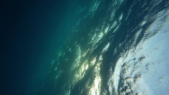 SLOW MOTION UNDERWATER, LENS FLARE: Crystal clear ocean wave breaking over the camera at golden sunset in the Caribbean. Cinematic shot of a tube wave splashing over camera filming the summer sunset.