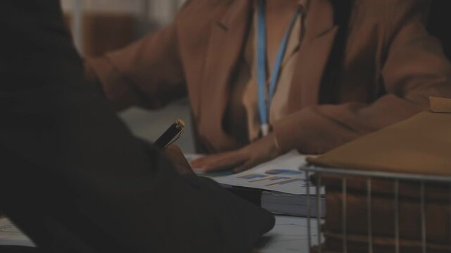 Close up of businessman or accountant hand holding pen working on calculator to calculate business data, accountancy document and laptop computer at office, business concept
