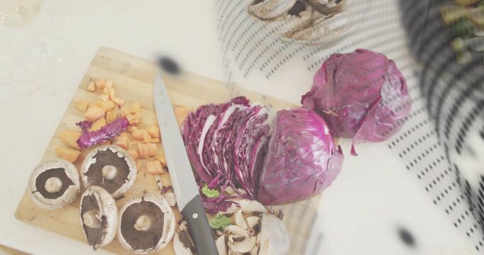 Board and knife holding veg, camera panning mesh overlay sweeping showing cabbage for food prep