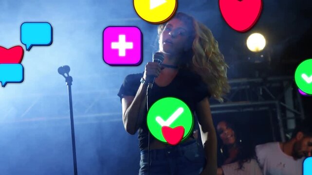 Singing lead singer holding wired mic in black crop top on stage, drawing growing reaction icons