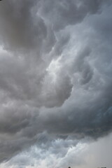 Fototapeta premium Dramatic swirling dark grey storm clouds filling the entire sky with turbulent patterns