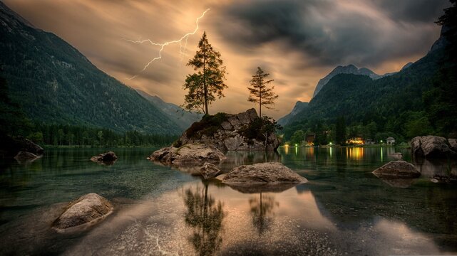 Dramatic lightning strike over Hinders Lake in the Bavarian Alps at twilight.