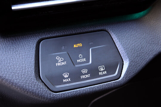 Close-up of black matte plastic headlight control panel in premium electric car. Dashboard for switching on the headlights and fog lights. Fog light symbols, MAX front defroster icon, mode button with