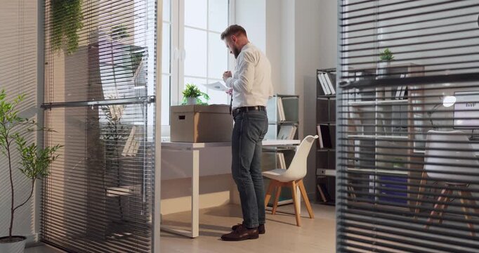 Businessman dismissal crisis in office with box. Layoff and resignation after bankruptcy show despair, unemployment, stress. Workspace with box implies job loss. Clear concept of job loss.