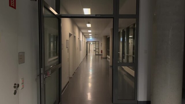 Empty hospital corridor in Germany at night. Dimly lit hallway of a modern medical facility after hours. Clinical interior, sterile environment for patient care and treatment. No people