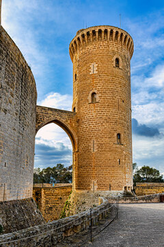 Majestuosa torre del homenaje de castillo medieval con puente de arco de piedra y cielo dram&aacute;tico con nubes en arquitectura hist&oacute;rica fortificada para viajes turismo y conceptos de fortaleza