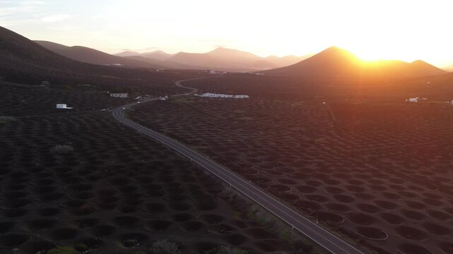 Lanzarote sunset illuminates unique volcanic fields and winding road