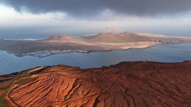 Lanzarote volcanic island landscape with La Graciosa and ocean at sunset