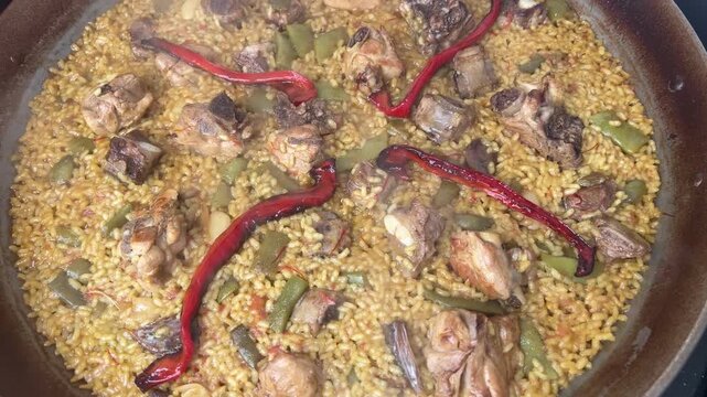 Steaming hot valencian paella cooking in a pan