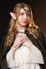 Obraz premium Beautiful girl dressed as elf on dark background