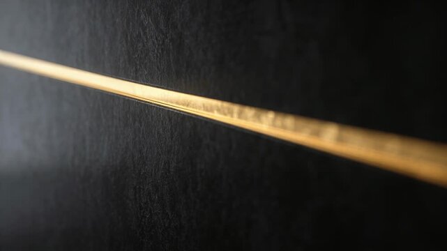 Golden strip reflecting shifting light in close-up, haze drifting, revealing texture for design