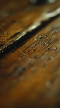 A close-up view of a wooden table featuring metal rivets