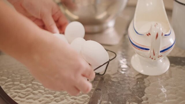 Assembling items for morning baking. Arranging eggs and supplies to create warm baking atmosphere. Setting up eggs and baking gear meticulously for comforting early morning kitchen activity