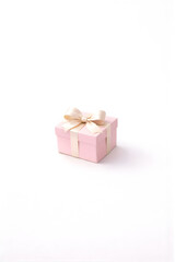 Obraz premium Minimalist pink gift box with satin ribbon on white