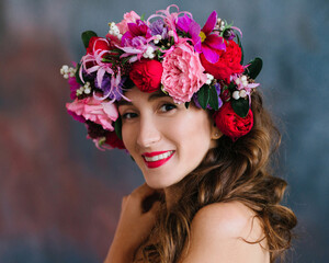 Naklejka premium Portrait of a beautiful woman wearing a vibrant flower wreath