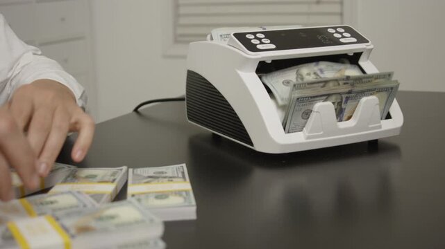 Hand counting dollars. Businessman hold money in hand. Business finance management in office. Dollar counting machine concept. Finance office scene with cash counter. Financial management.