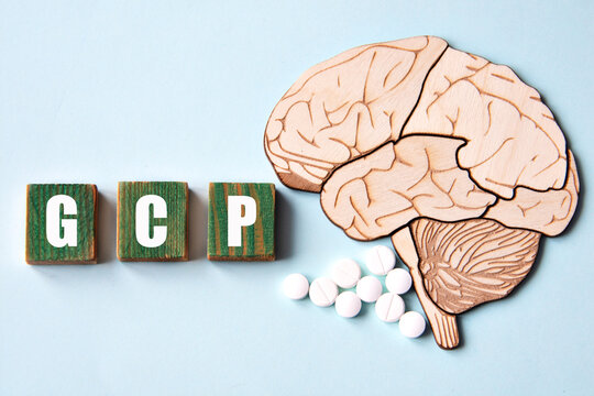GCP is an acronym depicted on wooden cubes on a blue background with a skull brain model.