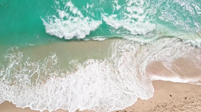 Waves ocean coastal beach. Drone aerial turquoise water. Foam pattern sandy shoreline. Summer tropical landscape paradise.