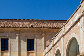 Naklejka premium Historic building facade with arches and blue sky in Menorca