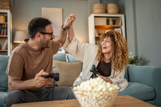 Couple celebrating online video game victory at home