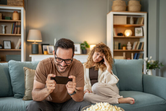 Man addicted to smartphone ignoring sad girlfriend