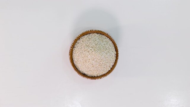 Animated amaranth seeds filling a bowl isolated on white background